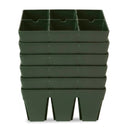 Stack of five dark green plastic six-cell seed starting trays nested together, each tray divided into two rows of three deep planting cells, on a plain white background.